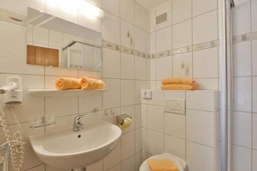 Baño blanco con lavabo y aseo en Gästehaus Knunbauer, en Mayrhofen