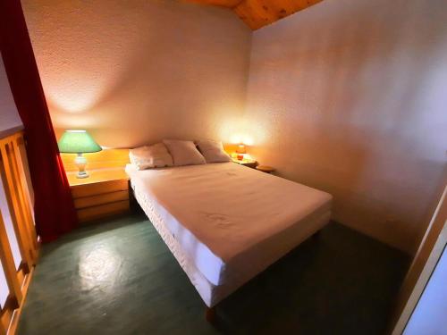 une chambre avec un lit avec deux lampes dessus dans l'établissement Résidence Jetay - Appartement avec mezzanine pour 6 personnes MAE-4624, aux Menuires