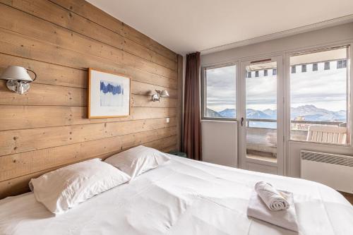 Le Mirador - Immodreams - Avoriaz في أفورياز: غرفة نوم بسرير أبيض ونافذة