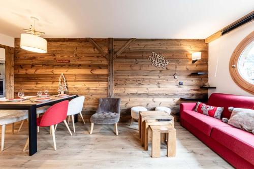 - un salon avec un canapé rouge et des murs en bois dans l'établissement L Elinka - Immodreams - Avoriaz, à Avoriaz