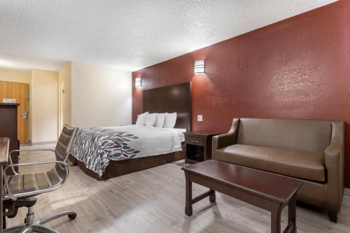 a hotel room with a bed and a chair at Red Roof Inn La Marque in La Marque