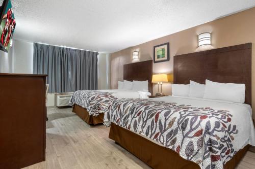 a hotel room with two beds and a window at Red Roof Inn La Marque in La Marque
