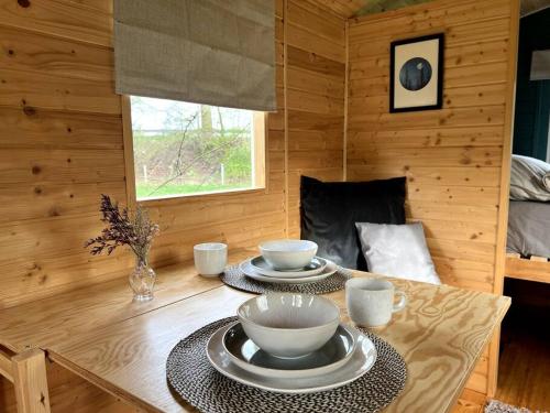 a wooden room with two bowls and plates on a table at Kuscheltage im Zirkuswagen am Kanal im Münsterland in Recke