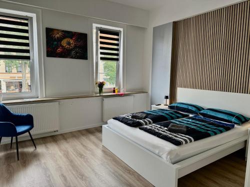 a bedroom with a large bed with blue pillows at Pension Oleee in Erfurt
