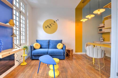 un salon avec un canapé bleu et des chaises dans l'établissement Chez Paulette au Petit Palais, à Périgueux