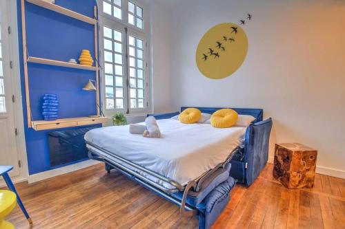 une chambre avec un lit avec des oreillers jaunes dessus dans l'établissement Chez Paulette au Petit Palais, à Périgueux