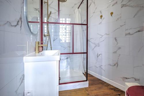une salle de bain blanche avec une douche et un lavabo dans l'établissement Chez Paulette au Petit Palais, à Périgueux