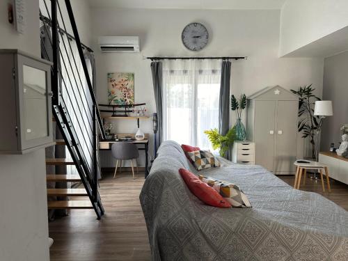 une chambre avec un lit et une horloge au mur dans l'établissement Jolie Villa climatisée piscine parking Perpignan, à Perpignan