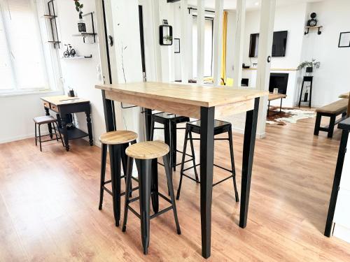 a wooden table and stools in a room at Villa de charme avec piscine privée in Ouzouer-sur-Loire