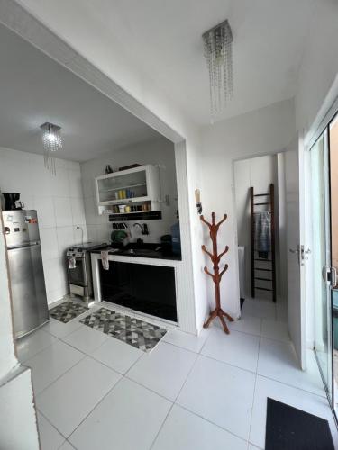 a white kitchen with a stove and a microwave at Casa com piscina, churrasqueira e terraço com vista pro mar! in Mangaratiba