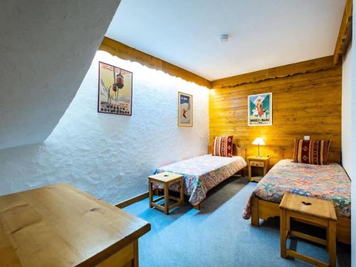 une chambre d'hôtel avec deux lits et une table dans l'établissement Résidence Boulevard - BOULEVARD A18 MAE-6241, à Les Allues