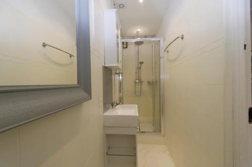 une salle de bain avec une douche, un lavabo et un miroir dans l'établissement Forville Coeur de Cannes, à Cannes