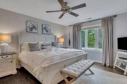 a bedroom with a large bed with a ceiling fan at The Retreat at 56 - Beach Oasis in Palmetto Dunes in Hilton Head Island