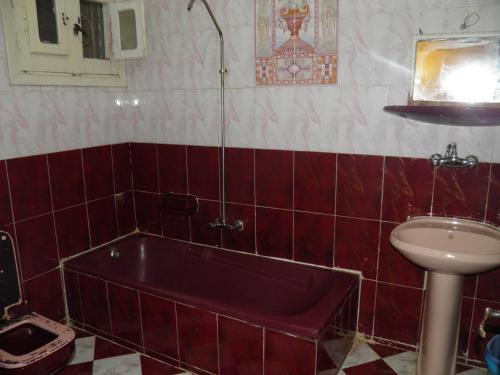 a bathroom with a red tub and a sink at لؤلؤه الفيروز in Marsa Matruh