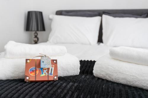 a bag sitting on a bed with white towels at São Vicente Bedrooms in Lisbon