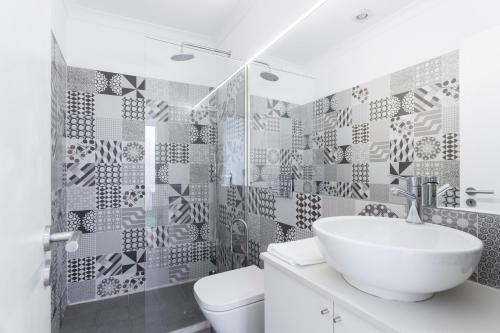 a bathroom with a white sink and a toilet at São Vicente Bedrooms in Lisbon
