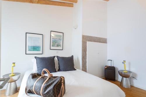 a bedroom with a bed with a bag on it at São Vicente Bedrooms in Lisbon