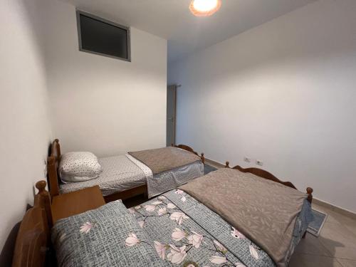 a room with three beds and a flat screen tv at City Apartment in Shkodër
