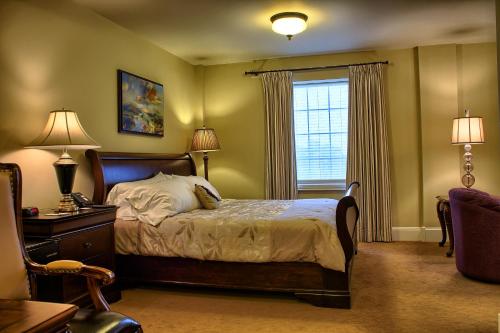a bedroom with a bed and a window at Grant Hall Hotel in Moose Jaw