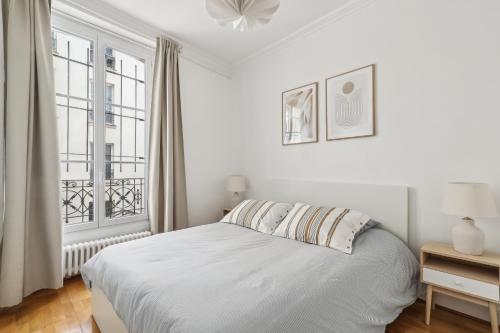 une chambre blanche avec un lit et une fenêtre dans l'établissement Charming Apartment 1 BR 4 persons - Opera Bourse, à Paris
