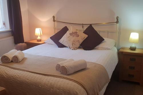 une chambre avec un lit avec des serviettes dessus dans l'établissement Bwlch Cottage, à Gwaynynog