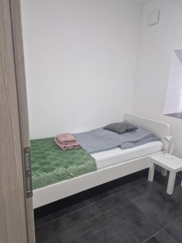 a bedroom with a white bed with a green blanket at Laura in Freudenburg