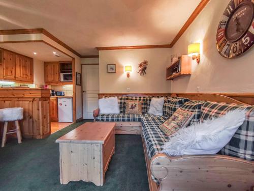 un salon avec un canapé et une horloge au mur dans l'établissement Appart cosy avec cuisine équipée, balcons à Valmorel - FR-1-356-498, à Valmorel