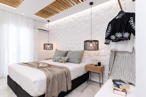 a bedroom with a large bed and two hanging lights at Anatoli Hotel in Naxos Chora