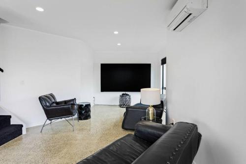 a living room with a couch and a tv at Awesome Designer 3BR Apt in the Heart of Manukau in Auckland