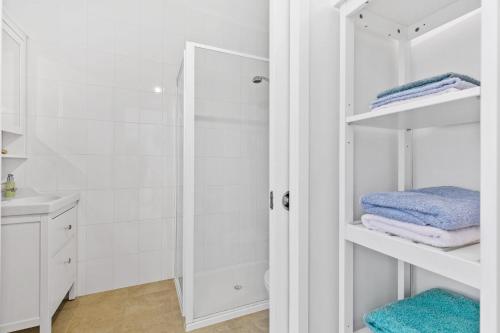 Un baño blanco con ducha y toallas. en The Treehouse at Long Beach, en Long Beach