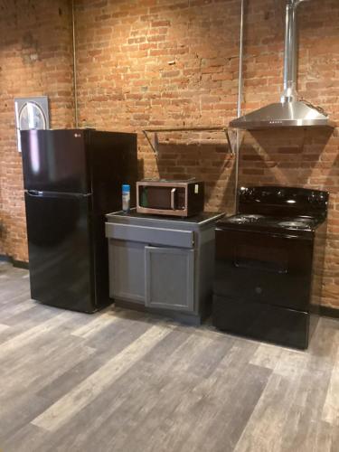 a kitchen with a black refrigerator and a microwave at Downtown Cleveland Historic District in Cleveland