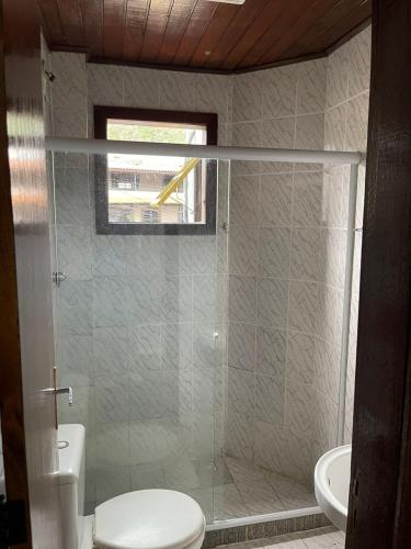 a bathroom with a shower with a toilet and a sink at Pousada Terra Do Sol in Arraial do Cabo