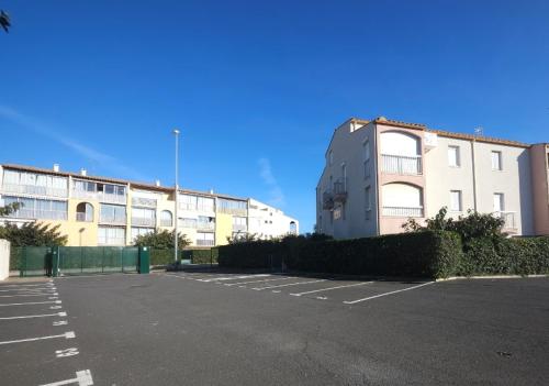 un parking vide devant un immeuble dans l'établissement Plage Sud France, au Cap d'Agde