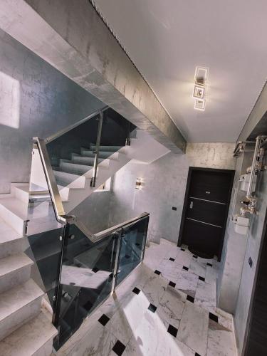 a staircase with a glass railing in a building at Apartament GabRox in Mamaia Sat/Năvodari