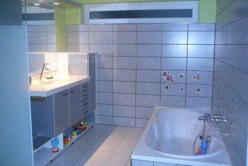 La salle de bains blanche est pourvue d'un lavabo et d'une baignoire. dans l'établissement Appartement 4 personnes du Sable, à Marlenheim