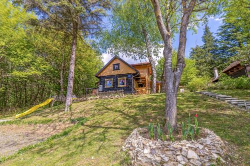 a log cabin in the woods with a tree at Chalet Birchwood With Whirlpool and Sauna - Happy Rentals in Hum Breznički