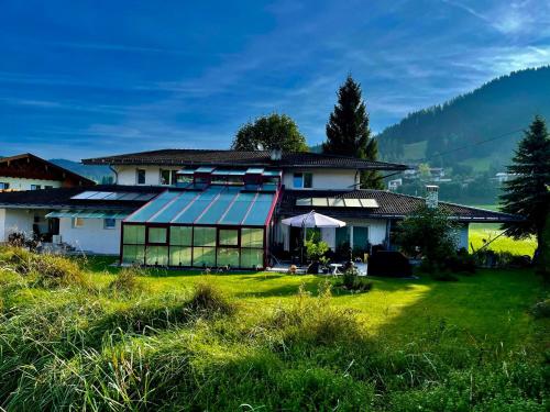 a house with a solarium on a green lawn at Villa Aigner in Achenkirch