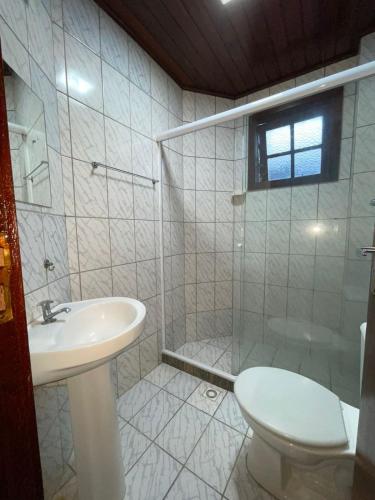 a bathroom with a sink and a toilet and a shower at Pousada Terra Do Sol in Arraial do Cabo