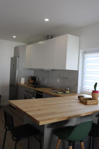 a kitchen with white cabinets and a wooden counter top at Villa Cerva Home in Cerva