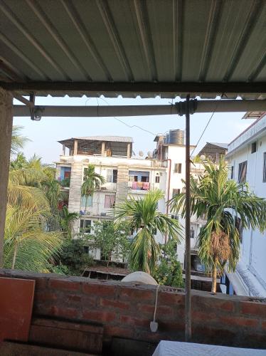 a view of a building from a patio with palm trees at kirtti inn AC double in Guwahati