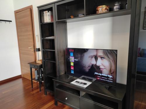 a flat screen tv in a black entertainment center at Margot's House Rho in Rho