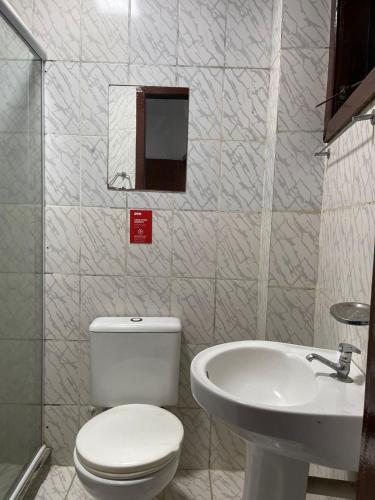 a bathroom with a toilet and a sink at Pousada Terra Do Sol in Arraial do Cabo