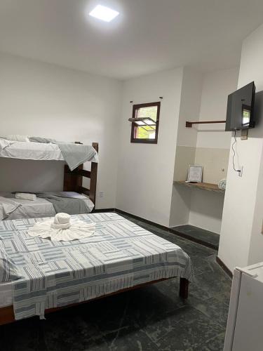 a bedroom with a bed and a tv in it at Pousada Terra Do Sol in Arraial do Cabo