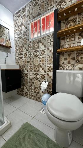 a bathroom with a white toilet and a sink at Casa da Floresta in Rio de Janeiro