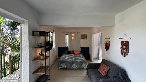 ein Wohnzimmer mit einem Bett und einer Couch in der Unterkunft Casa da Floresta in Rio de Janeiro