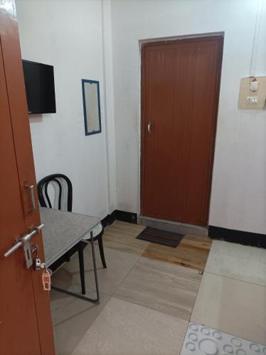a room with a door and a table and a table and chair at Kirtti Inn Mini Home Non AC in Lokpriya Gopinath Bordoloi International