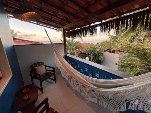 a hammock on a balcony with a view of the ocean at Pousada Nascente do Sol in Ilha de Boipeba