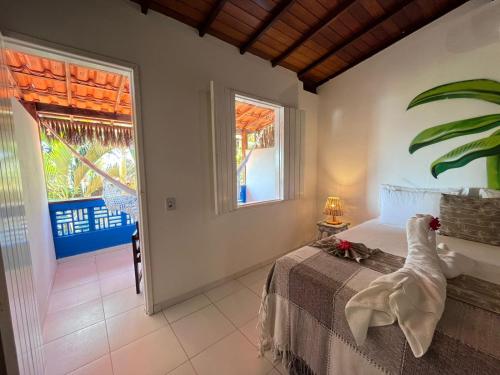 a bedroom with a bed and a large window at Pousada Nascente do Sol in Ilha de Boipeba