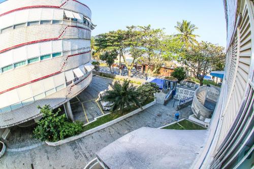 an overhead view of a building with trees in front of it at 12F- Pe na Areia do Tombo-2 Quartos, Ar Cond, 2w, 1 vaga e Roupas de Cama in Guarujá