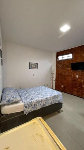 a bedroom with a bed with a blue comforter at Pousada Terra Do Sol in Arraial do Cabo